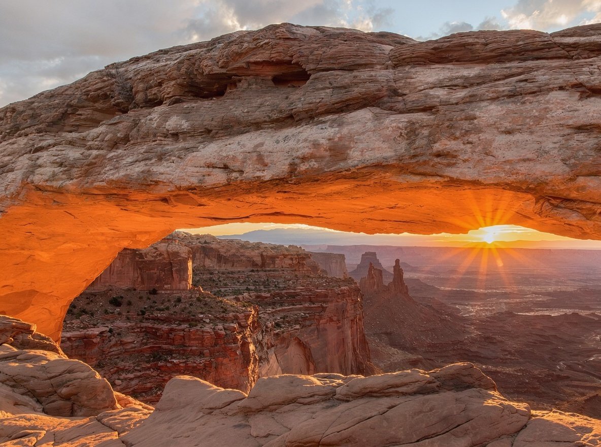 Mesa Arch framing a vast canyon at sunrise in Canyonlands National Park
